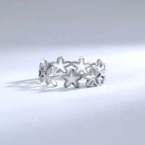 Detailed close-up of hollowed-out star pattern ring in polished silver finish
