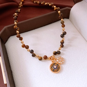 Détail du collier en œil de tigre plaqué or 18 carats avec œil protecteur et étoile
