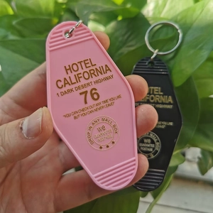 Close-up of pink and black Hotel California vintage motel key tags with gold engraving