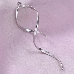 Macro view of 304 stainless steel ribbon pendant on pink silk fabric background