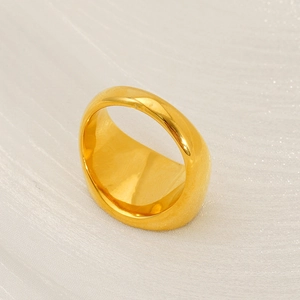 Polished wide gold stainless steel band ring with minimalist retro style on silk