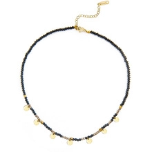 Close-up of black beaded necklace featuring gold circular discs and adjustable lobster clasp