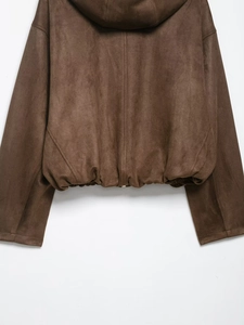 Detail view of brown faux suede cropped jacket featuring elastic hem and soft velvet texture