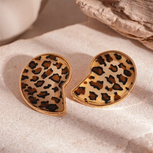 Macro view of gold-trimmed leopard print resin earrings with vintage comma shape design
