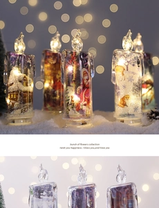 Macro shot of LED Christmas candles with Santa prints on snowy background with warm bokeh