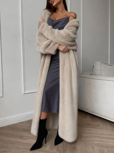 Lungo cardigan bianco in finta pelliccia abbinato ad abito sottoveste grigio e stivali neri