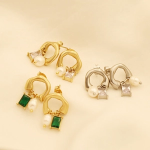 Detailed macro view of gold and silver earrings with pearls and colorful zircon stones