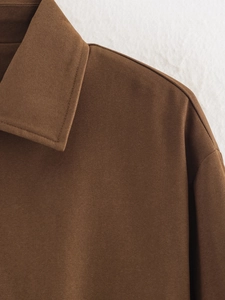 Détail d'une veste matelassée marron foncé montrant le col et la texture du tissu