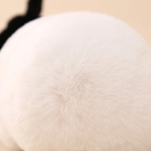 Close-up detail of soft white plush material on the cute cartoon panda earmuffs for kids