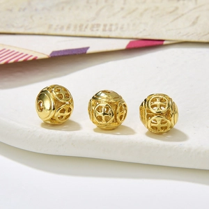 Macro detail of golden hollow beads with cross pattern for DIY jewelry making