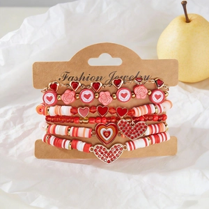 Detalle del conjunto de pulseras multicapa con cuentas rojas de corazón en tarjeta
