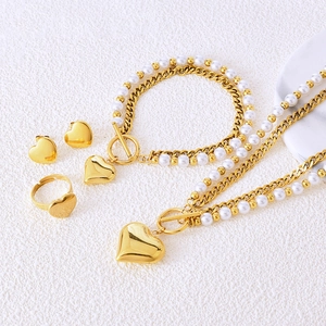 Golden pearl jewelry set featuring heart pendants, necklace, bracelet, and earrings