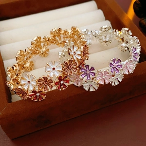 Nahaufnahme von Emaille-Blumenarmbändern in Gold- und Silberschicht auf Schmuckschatulle