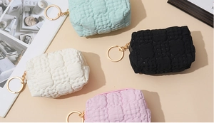 Flat lay macro of waffle texture coin purses in four macaron colors with gold keychains