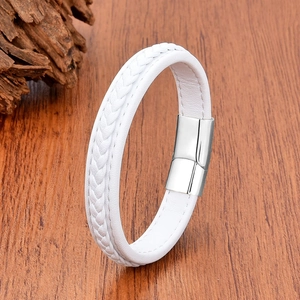 Detail of white braided leather bracelet with silver magnetic clasp on wood background