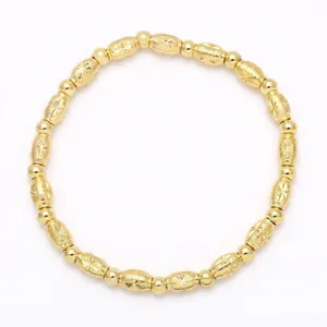 Close-up of gold beaded bracelet with starburst engraved oval charms on white background