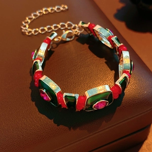 Detail of vintage silver bracelet with green enamel squares and pink gemstone accents