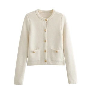 Detail view of cream knit cardigan featuring ornate gold buttons and textured pockets
