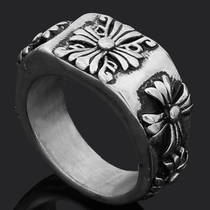 Detail of vintage silver finish ring featuring an embossed floral cross design