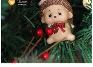 Detailed view of a resin Christmas hedgehog ornament nestled in a green pine tree