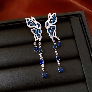 Détail des boucles d'oreilles papillon en zircon bleu avec longues franges en argent