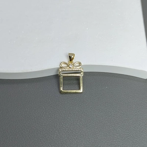 Macro shot of gold-plated Christmas tree charm with zircon stones and hollow bow design