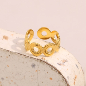 Vue détaillée d'une bague géométrique dorée avec cercles ajourés sur support pierre