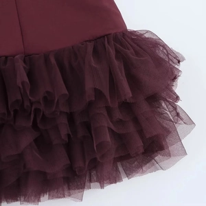 Dettaglio gonna a balze rosso vino che mostra la texture del tulle e le balze multistrato