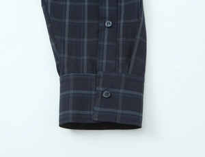 Detailed view of the plaid poplin shirt cuff with dark blue buttons and white grid