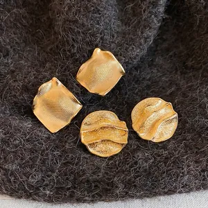 Set de boucles d'oreilles dorées avec motifs carrés et disques à texture métallique