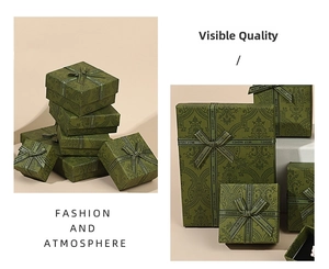 Detail of vintage emerald green jewelry gift boxes with embossed vine patterns and silk ribbons