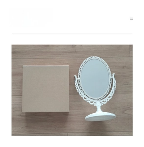 Detailed view of white vintage oval desktop mirror with baroque floral relief and packaging