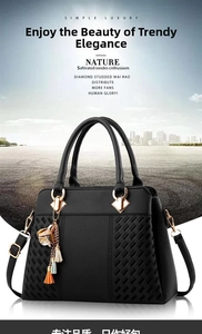 Detail of black PU leather handbag showing woven texture base and gold tassel charm