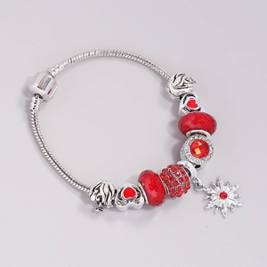 Silver charm bracelet with red glass beads, heart charms, and a delicate snowflake pendant
