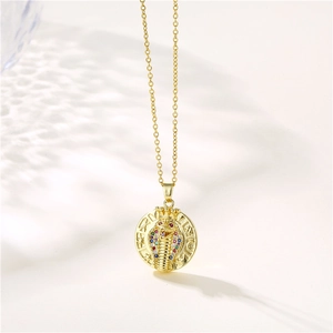 Gold cobra necklace with zircon-set pendant and crown detail on a minimalist chain