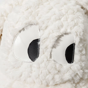 Gros plan sur la texture en peluche blanche et les yeux de dessin animé du chapeau bob d'hiver