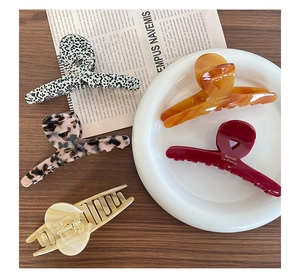 Flat lay of acetate hair claws in leopard and amber patterns on a wooden desk