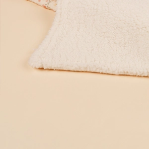 Close-up of thick white sherpa fleece fabric showing soft texture and neat stitching