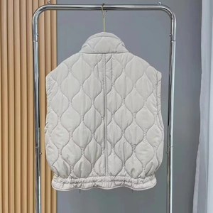 Detail of cream quilted vest showing intricate gourd pattern stitching and light texture