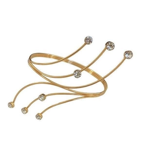 Elegant gold coiled arm cuff featuring sparkling round rhinestones on a white background