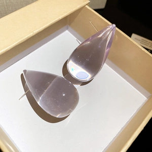 Close-up of elegant lavender acrylic waterdrop earrings in a beige gift box
