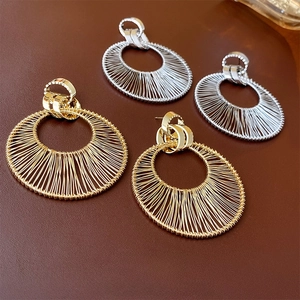 Exaggerated metal hollow hoop earrings in gold and silver with woven texture design
