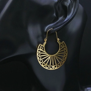 Bohemian gold cutout fan earrings with vintage filigree patterns on black mannequin