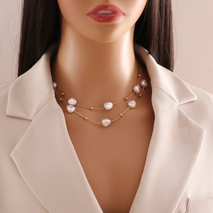Detail of elegant layered pearl necklace with baroque pearls and gold beads on a model