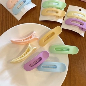 Close-up of matte candy-colored hair clips in pink, yellow, purple, and green shades