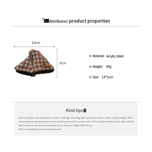 Detail view of acrylic hair claw with houndstooth fabric finish and handmade label