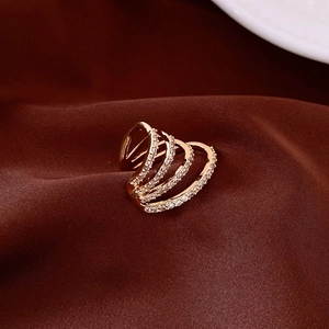 Macro shot of gold-plated multi-layer rings with shimmering zircon inlay on silk