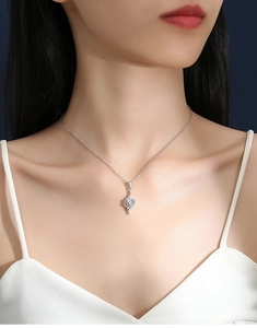Close-up of S925 sterling silver necklace with sparkling D color moissanite pendant on model