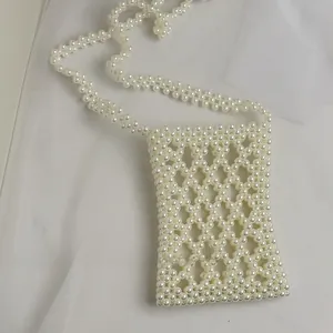 Detail of handmade pearl beaded mini crossbody bag with lattice weave pattern