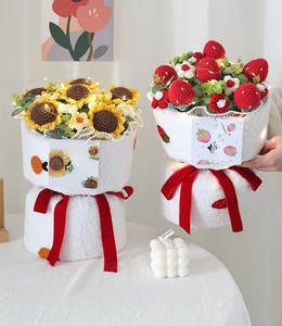 Detail of handmade crochet sunflower and strawberry bouquet with warm LED fairy lights